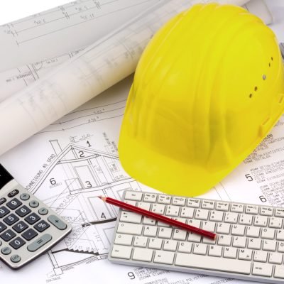 an architect's blueprint with the hard hat of a construction worker. symbolic photo for funding and planning of a new house.