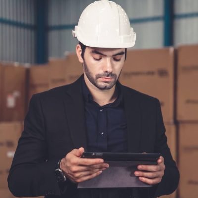 Factory manager using tablet computer in warehouse or factory . Industry and supply chain management concept .